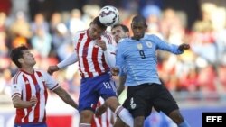 El centrocampista paraguayo Richard Ortíz (2i) remata de cabeza ante el delantero uruguayo Diego Alejandro Rolán (d).