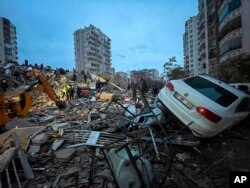 Cuadrillas de socorristas buscan entre los escombros de un edificio a sobrevivientes tras un sismo, en Adana, Turquía. (DIA Images vía AP)