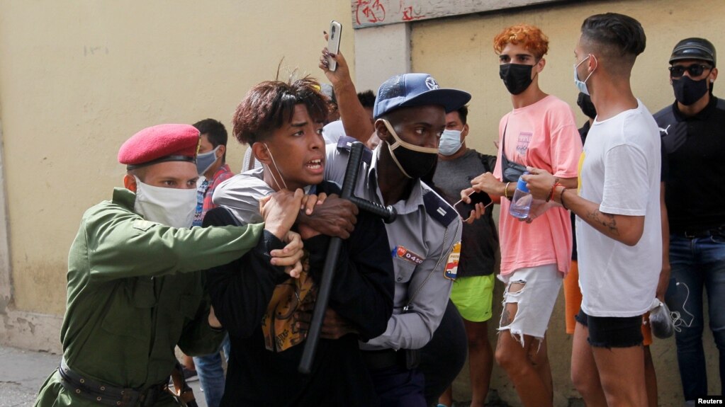 Policías vestidos de civil detienen a un menor durante protestas el 11 de julio de 2021. REUTERS / Stringer