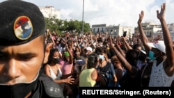 Personas reaccionan durante las protestas en contra del gobierno cubano.