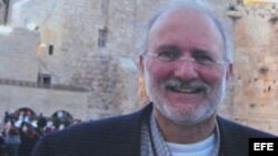 Una persona sostiene una pancarta en la que pide que sea liberado el contratista Alan Gross.
