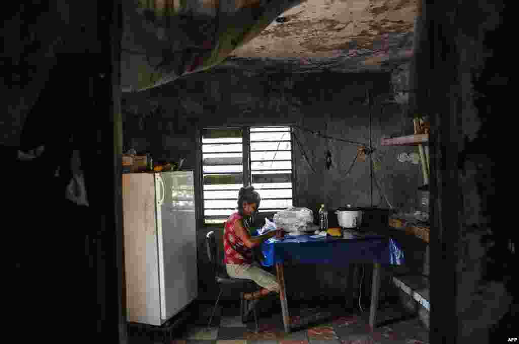 Una señora escoge arroz en su casa en El Caney, Santiago de Cuba el 21 de junio de 2017.&nbsp;Más de un 50% de los cubanos vive por debajo del umbral de pobreza.&nbsp;&nbsp;AFP PHOTO/YAMIL LAGE