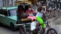 Usando máscara de protección contra el coronavirus, un hombre trasporta a clientes en un bicitaxi en La Habana. (AP/Ramon Espinosa)