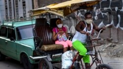 Usando máscara de protección contra el coronavirus, un hombre trasporta a clientes en un bicitaxi en La Habana. (AP/Ramon Espinosa).