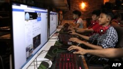 Esta fotografía tomada el 18 de diciembre de 2018, muestra a jóvenes de Birmania que navegan por su página de Facebook en una tienda de Internet en Yangon. (AFP).