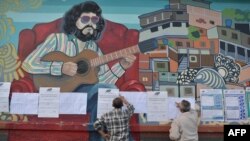 Votalntes chean las listas de candidatos en un colegio electoral de Caracas.