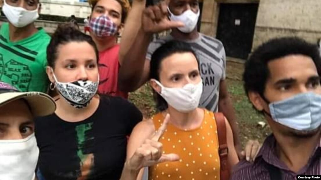 Omara Ruiz Urquiola (al centro de la foto) junto a varios activistas indagan por músicos detenidos en La Habana.