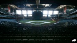 Un oscurecido Chase Field, hogar de los Arizona Diamondbacks de la Liga Nacional de Béisbol, se encuentra vacío en medio de la pandemia de coronavirus. (AP Photo/Ross D. Franklin, File)