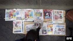 Diarios con la noticia de la victoria de Nicolás Maduro en primera página son exhibidos para la venta hoy, lunes 15 de enero de 2013, en Caracas (Venezuela). La oposición ha pedido el recuento de votos tras la jornada electoral de este domingo que, según