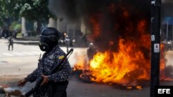 Policías prestan guardia tras una explosión que alcanzó varias motocicletas en Caracas.