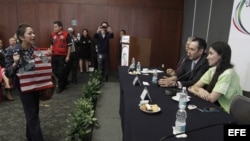 Yoani Sánchez (d) es interrumpida por miembros del Movimiento Mexicano en Solidaridad con Cuba, en el Senado de México.