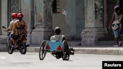 Un hombre con discapacidad se traslada en una silla de ruedas improvisada. REUTERS/Desmond Boylan