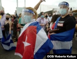 Exiliados cubanos, con mascarillas, protestan contra el gobierno cubano.