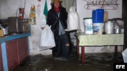 Un hombre trata de salvar algunas pertenencias en su casa inundada el jueves, 24 de mayo de 2012, en Yaguajay, provincia de Sancti Spíritus, Cuba.