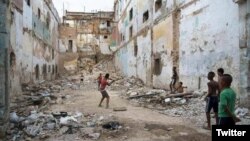 Niños juegan pelota en un edificio en ruinas en La Habana.