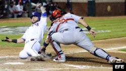 El receptor de los Cardenales de San Luis Yadier Molina (d) saca out al jugador Mike Napoli (i) de los Vigilantes de Texas.