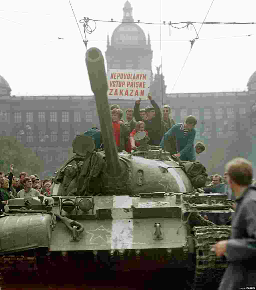 Los checos viajan en un tanque soviético en la Plaza de Wenceslao alrededor de las 8-9 a.m. del 21 de agosto. En esta etapa, la atmósfera todavía era relativamente relajada, según Hajsky. &quot;Mucha gente esencialmente todavía no se daba cuenta de que era un ataque planeado&quot;, dice. &quot;Pensaron que era un ejercicio militar o algo así ... En esta foto, puedes ver que hay niños en el tanque. Como si estuvieran haciendo un recorrido en un parque de atracciones&quot;.