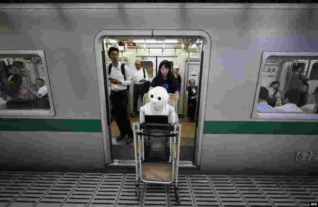Tomomi Ota empuja el carrito con Pepper en el metro de Tokio.