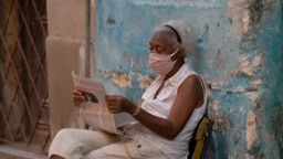 Una señora lee la prensa en la calle.