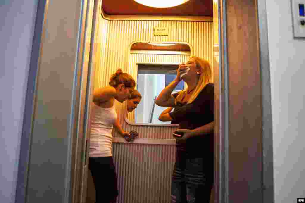 Dos mujeres afectadas por gases lacrimógenos toman un ascensor en inmediaciones de la Plaza Altamira de Caracas (Venezuela).