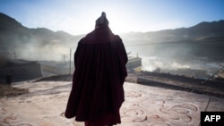 Monje budista tibetano contempla la salida del sol durante celebración de Año Nuevo Tibetano. (Johannes Eisele / AFP).