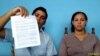 Carlos Amel Oliva, de la dirección nacional de UNPACU, y Nelva Ismaray Ortega Tamayo, esposa de José Daniel Ferrer y activista de la organización, muestran el documento de la Fiscalía.