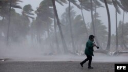Una mujer camina bajo la lluvia a la llegada de la tormenta tropical Erika a República Dominicana el viernes.