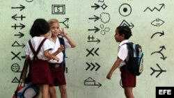 Tres niños posan con una bandera cubana durante el primer día del curso escolar 2015-2016 hoy, martes 1 de septiembre de 2015, en La Habana (Cuba). Cuba comienza hoy el curso escolar 2015-2016 con cerca de dos millones de estudiantes en más de 10.300 esc