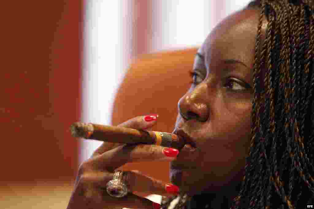 Una mujer posa para una foto fumándose un tabaco durante la inauguración del Festival del Habano, en La Habana.