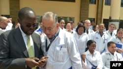 El profesor Anyang Nyongo (L), gobernador de Kisumu, habla con uno de los 100 médicos cubanos que dorman parte del convenio entre lso dos países