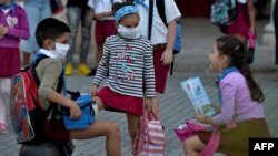 Niños usan máscaras en La Habana, Cuba, donde las autoridades no han decretado un cese de las actividades escolares antes el coronavirus.