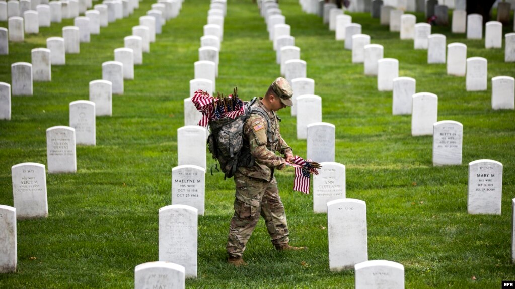 Soldados depositan banderas americanas en cada lápida durante una ceremonia por el Día de los caídos, en el Cementerio Nacional de Arlington, en Virginia.