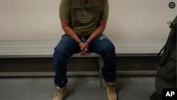 Un inmigrante aguarda a ser procesado en un centro de detención migratorio en Los Ángeles. (AP Foto/Damian Dovarganes, File)