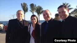 Yoani Sánchez en la Ermita de la Caridad, entre el arzobispo Thomas Wenski, a la izquierda, y el párroco Juan Rumín Domíguez, a la derecha.
