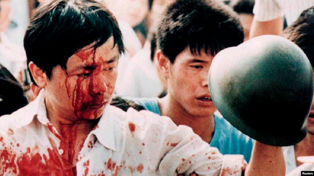 Un manifestante herido sostiene el casco de un militar en la Plaza de Tiananmen el 4 de junio de 1989 (Archivo/Shunsuke Akatsuka/Reuters).