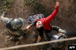 Un manifestante es detenido por la policía antimotines en Viña del Mar, Chile, el 24 de febrero durante las protestas contra el presidente Sebastián Piñera.