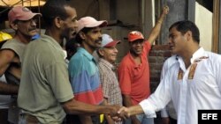 ARCHIVO. El presidente de Ecuador, Rafael Correa saluda a un grupo de obreros en La Habana Vieja (Cuba).