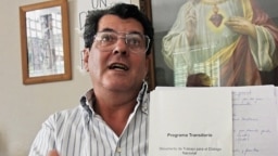 Oswaldo Payá muestra el documento temporal de un programa tentativo para un diálogo nacional durante una conferencia de prensa en su casa, en La Habana, el 17 de febrero de 2005.