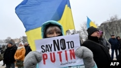 "Diga NO a Putin" pide el cartel que porta una manifestante pacífica en Ucrania