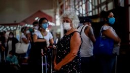 Viajeros usan maáscaras protectoras contra el coronavirus en el Aeropuerto Internacional José Martí de La Habana.