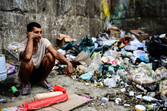 Ciudadano de Caracas esperando la basura para poder comer