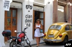 Una mujer camina frente a Clandestina, una tienda privada en La Habana.