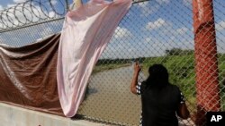 Una inmigrante cubana que busca asilo en EEUU mira sobre el Río Grande mientras espera en el Puente Internacional de Matamoros, México. (AP/Eric Gay)