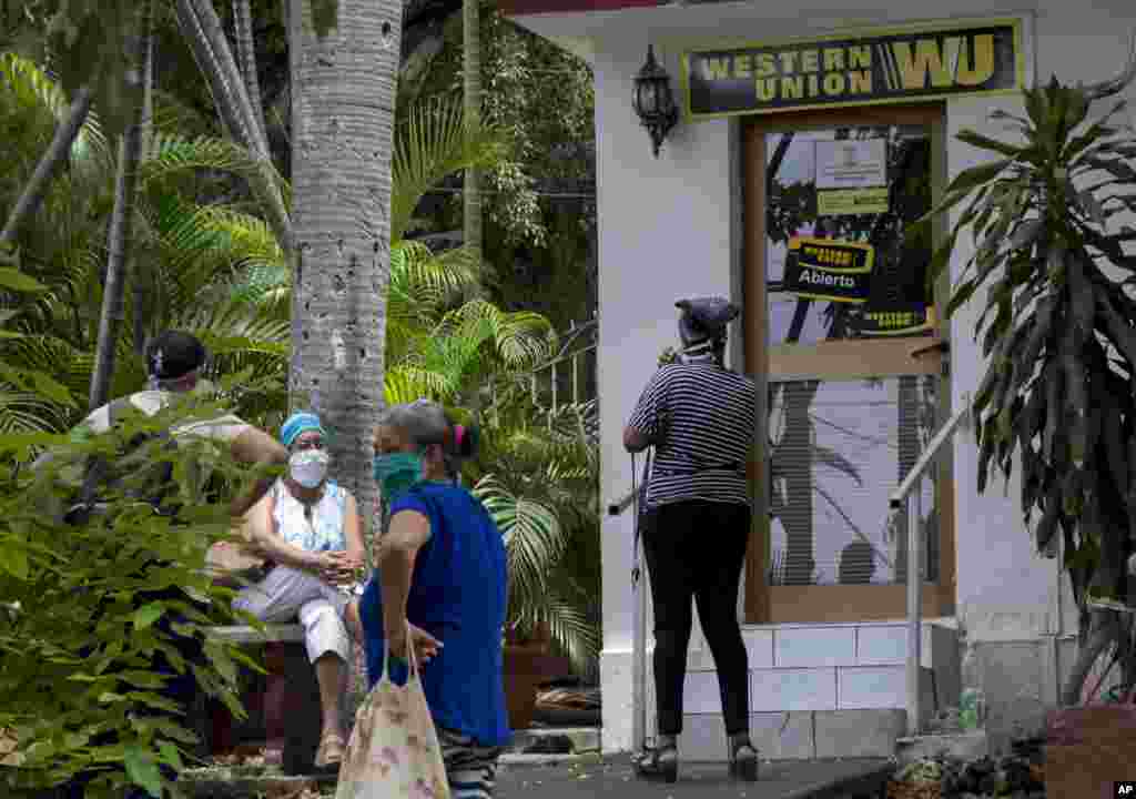 Personas esperan afuera de una oficina de la Western Union en La Habana.