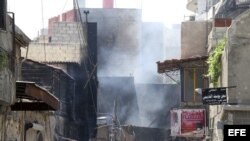Una humareda sale de un edificio dañado en el barrio de Midan, en Damasco, Siria, el día 20 de julio de 2012.