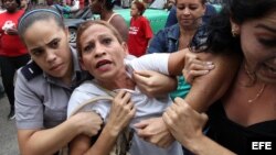 Una integrante de la Damas de Blanco es detenida, entre hostigamiento e insultos de sectores oficialistas, el 10 de diciembre de 2015, en La Habana (Cuba)