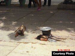 Cubana cocina en un parque porque le cortaron el servicio eléctrico al albergue donde vive.