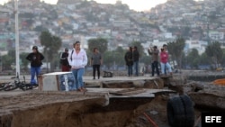 Un grupo de personas observa los destrozos causados por el tsunami posterior al terremoto de magnitud 8,4 en el puerto de Coquimbo (Chile).