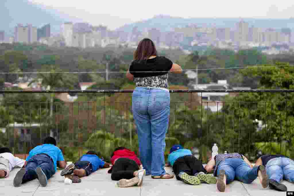 Niños se protegen de las bombas lacrimógenas el 7 de marzo de 2014, en una azotea cerca de la Plaza Altamira de Caracas (Venezuela).