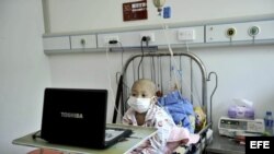 Fotografía de archivo de un niño enfermo de leucemia que ve una película a través de un ordenador portátil.
